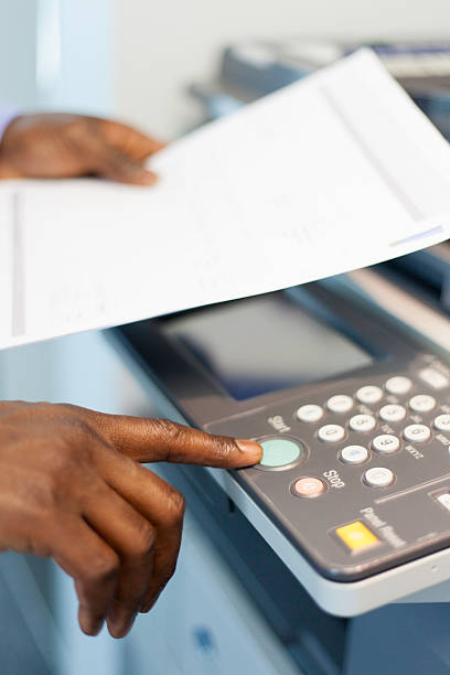 African businessman pressing the start button to print in Cape Town, South Africa.